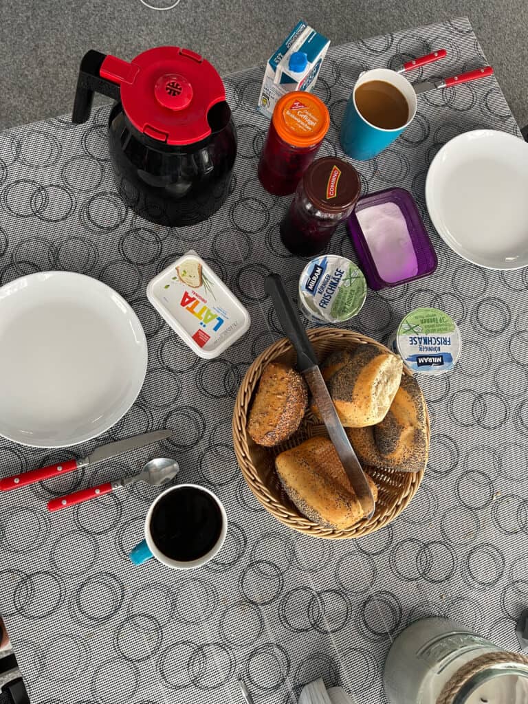Tisch mit zwei Tellern, Tassen und Marmelade